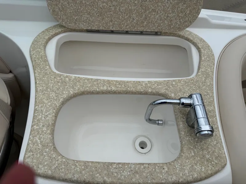 Slide: The Image of A sink with a faucet on a boat, surrounded by beige material. - 33