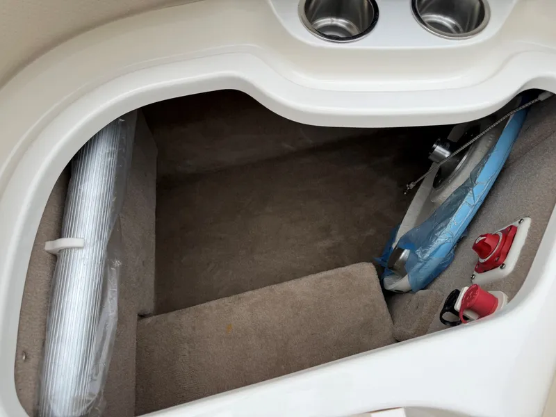 Slide: The Image of Interior of a 2006 Chaparral SSi 256 with carpeted flooring and cup holders. - 38