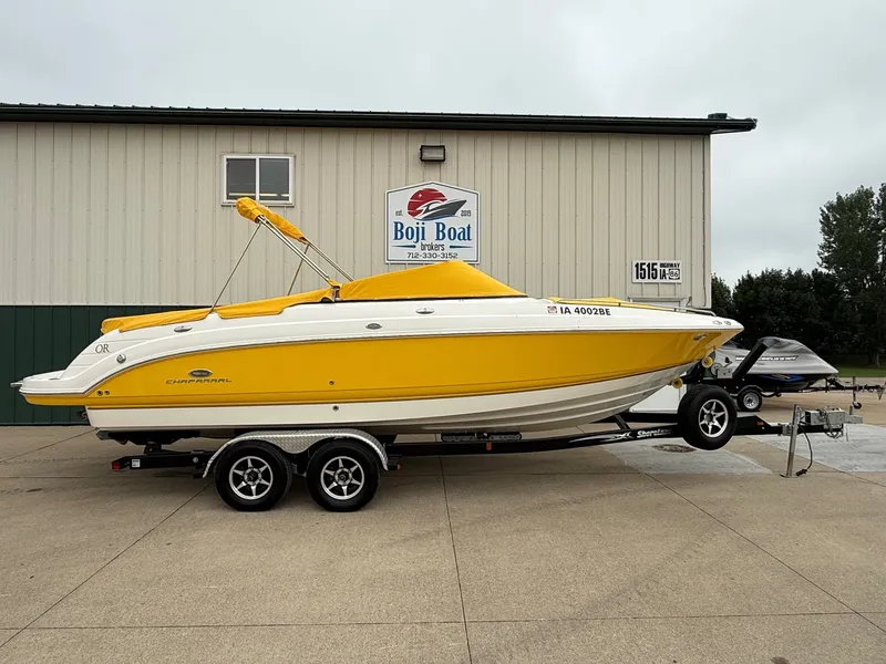 Slide: The Image of A yellow 2006 Chaparral SSi 256 boat on a trailer in front of a building. - 48