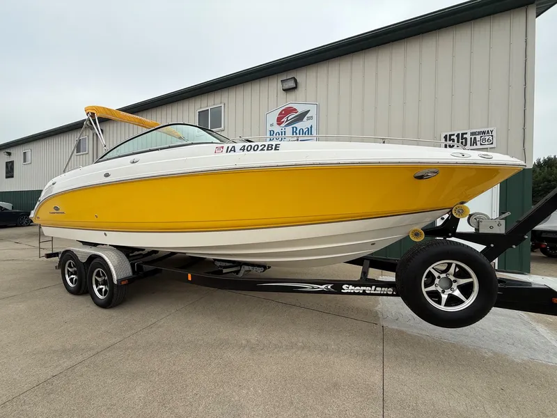Slide: The Image of A yellow 2006 Chaparral SSi 256 boat on a trailer in front of a building. - 1