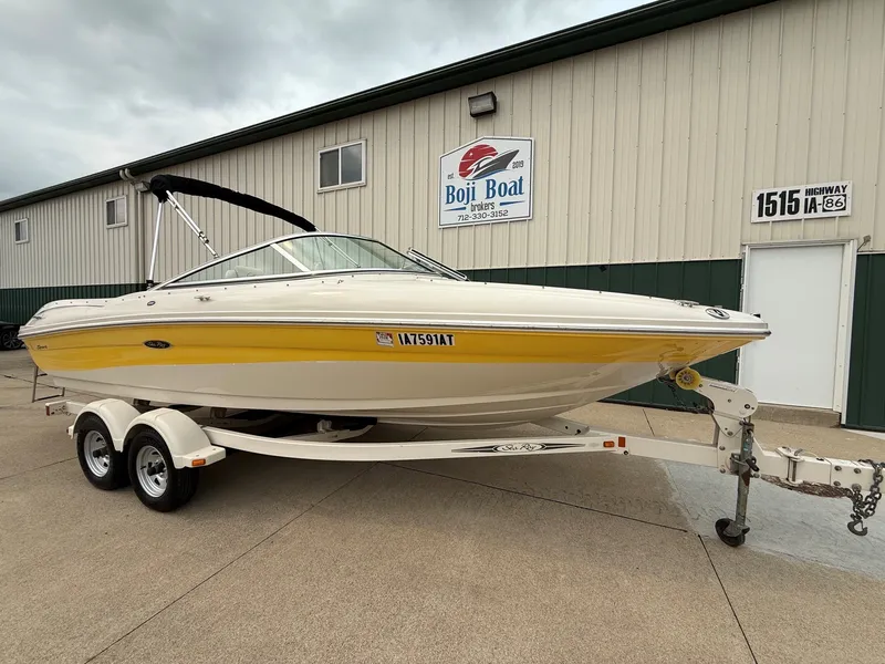 Slide: The Image of A yellow 2005 Sea Ray 200 Sport boat on a trailer in front of a building. - 1
