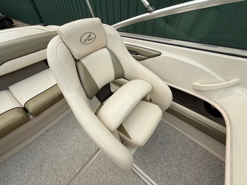 Slide: The Image of The interior of a 2005 Sea Ray 200 Sport with beige upholstery and sleek details. - 14