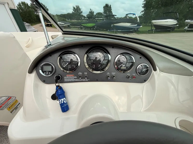 Slide: The Image of Dashboard of a 2005 Sea Ray 200 Sport with multiple gauges and a blue keychain. - 15
