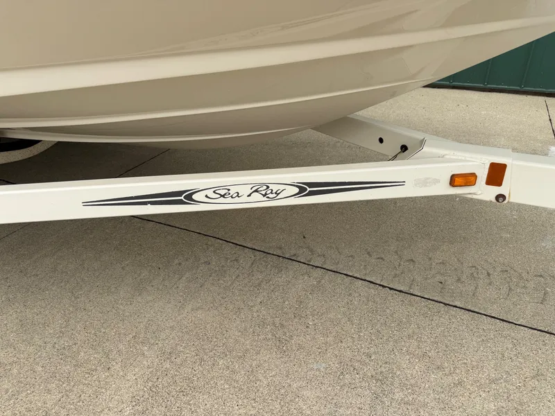 Slide: The Image of Close-up of a boat trailer with Sea Ray logo, parked on concrete ground. - 22