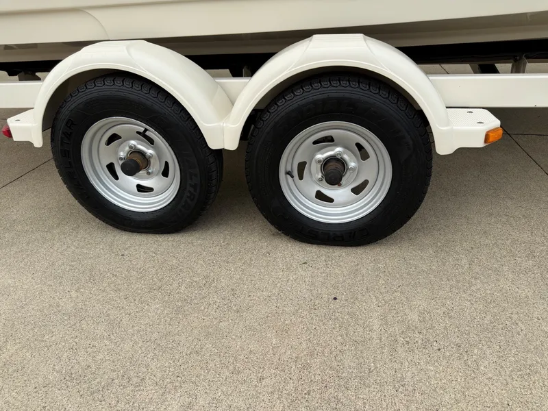 Slide: The Image of Dual trailer wheels on a concrete surface, part of a boat trailer. - 21