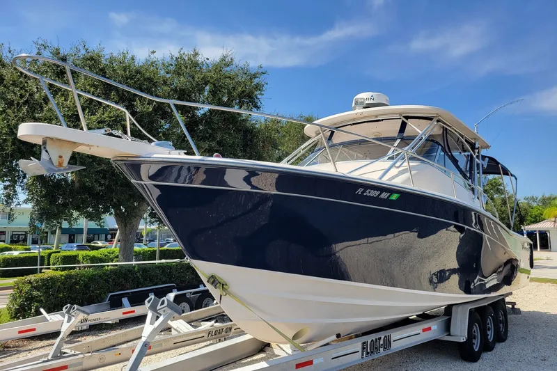 Slide: The Image of 2005 Grady-White Express 330 boat on trailer, parked outdoors under clear sky. - 2