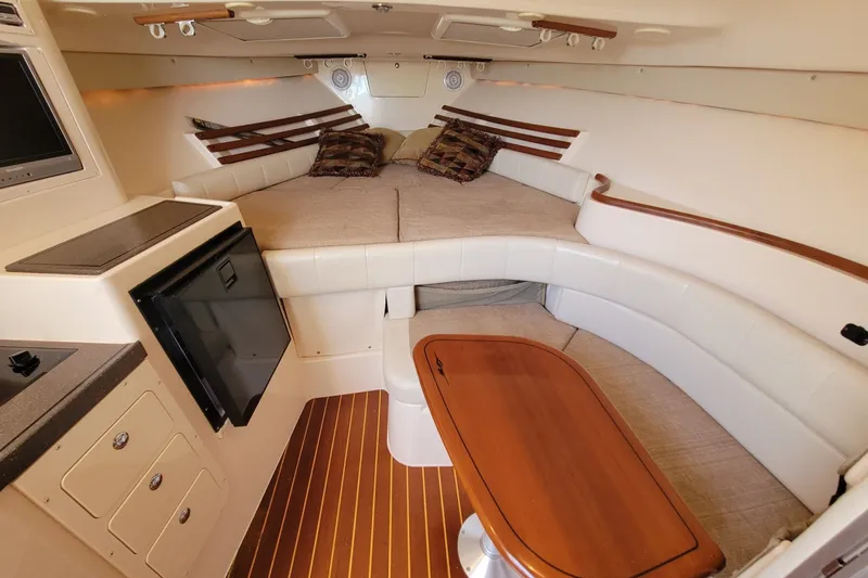 Slide: The Image of Interior of 2005 Grady-White Express 330 boat with cozy seating and wooden table. - 22