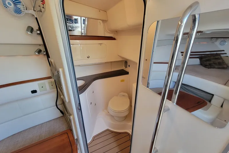Slide: The Image of Interior of 2005 Grady-White Express 330 boat, featuring a compact bathroom and sleeping area. - 20