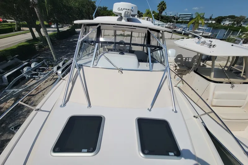 Slide: The Image of 2005 Grady-White Express 330 boat docked, featuring sleek design and Garmin equipment. - 15