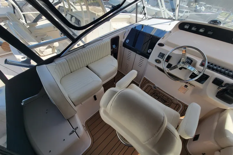 Slide: The Image of 2005 Grady-White Express 330 helm with steering wheel and seating, featuring modern controls. - 17