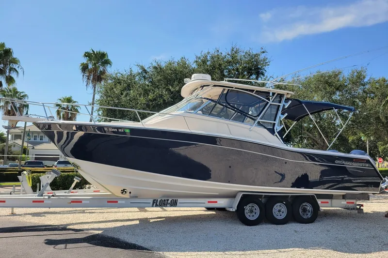The Image of 2005 Grady-White Express 330 boat on trailer, parked outdoors under clear sky. - 0