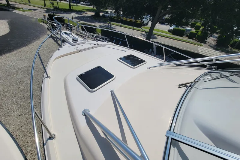 Slide: The Image of 2005 Grady-White Express 330 boat deck with railings and hatches, parked outdoors. - 14