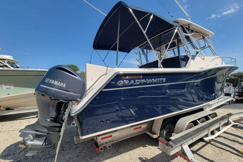 Slide: The Image of 2005 Grady-White Express 330 boat with Yamaha engine on trailer, under clear blue sky. - 11