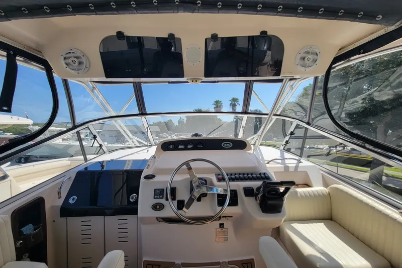 Slide: The Image of 2005 Grady-White Express 330 boat cockpit with steering wheel and control panel. - 19