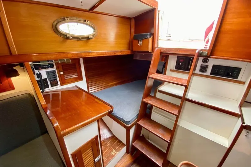 Slide: The Image of Interior of 1985 Nereia Yachts 38, featuring wooden cabinetry and compact sleeping area. - 17