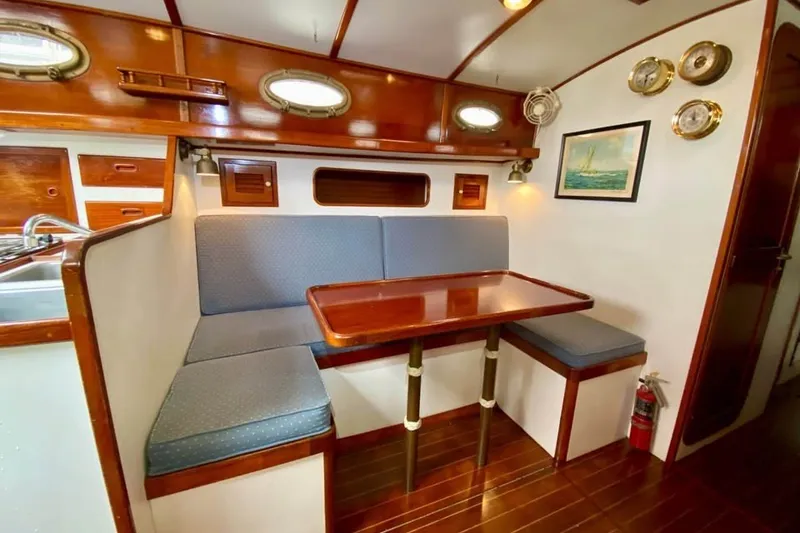 Slide: The Image of Interior of 1985 Nereia Yachts 38, featuring a cozy dining area with wooden accents. - 10