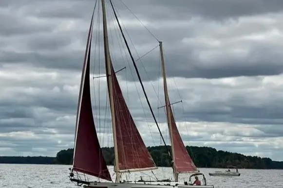 Slide: The Image of Vintage 1985 Nereia Yachts 38 sailing on a cloudy day with red sails. - 1