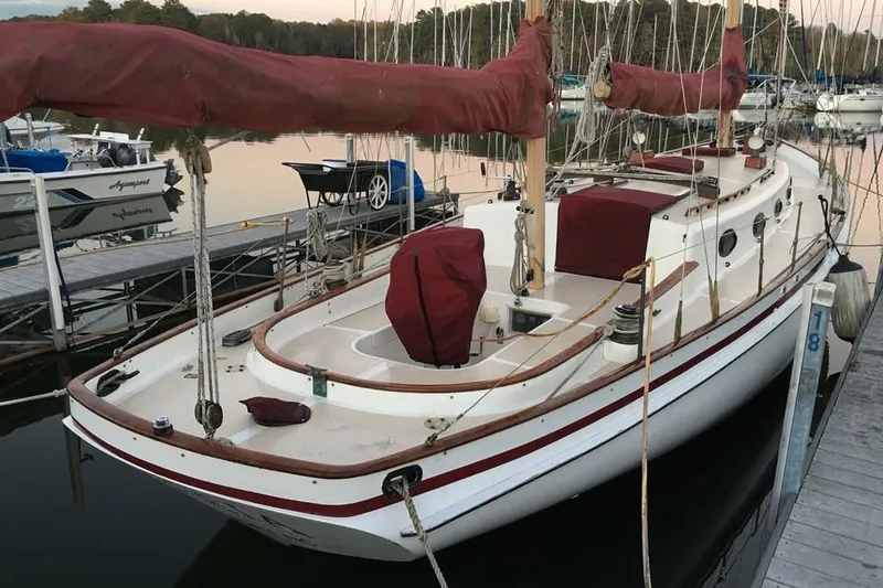 Slide: The Image of 1985 Nereia Yachts 38 sailboat docked at marina, featuring classic design and red covers. - 6