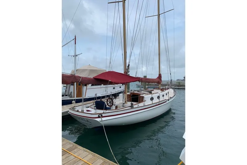 Slide: The Image of 1985 Nereia Yachts 38 sailboat docked at marina with red canopy. - 8