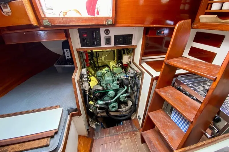 Slide: The Image of Engine room of 1985 Nereia Yachts 38, showcasing compact marine engine and wooden interior. - 16
