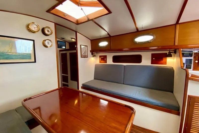 Slide: The Image of Interior of 1985 Nereia Yachts 38, featuring wooden table, seating, and nautical decor. - 11