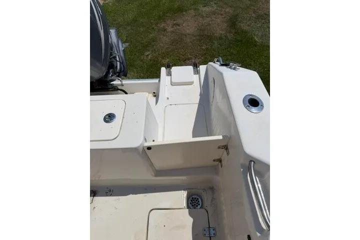Slide: The Image of 2010 Cobia 216 Center Console boat deck with storage compartments and seating area. - 21
