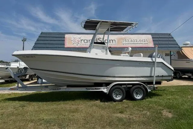 The Image of 2010 Cobia 216 Center Console boat on trailer, displayed outdoors. - 1