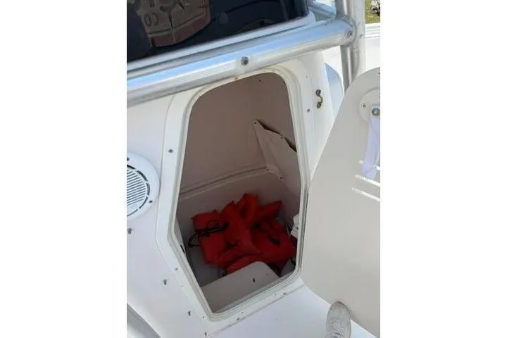 Slide: The Image of 2010 Cobia 216 Center Console storage compartment with life jackets inside. - 14