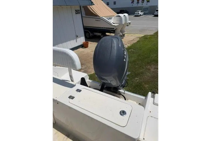 Slide: The Image of 2010 Cobia 216 Center Console boat with outboard motor in a marina setting. - 20
