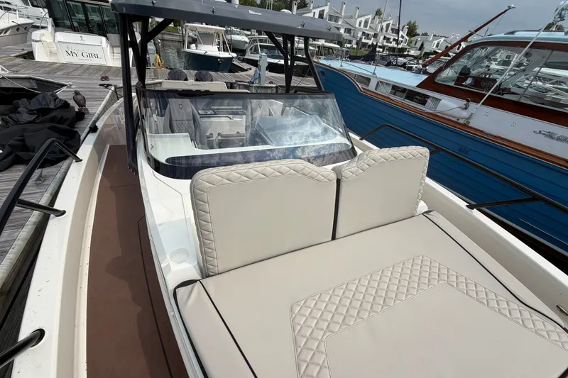 Slide: The Image of 2025 Navan S30 boat with luxurious seating at a marina. - 17