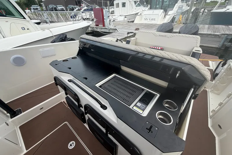 Slide: The Image of Luxury outdoor kitchen on 2025 Navan S30 boat, featuring grill and cup holders. - 10