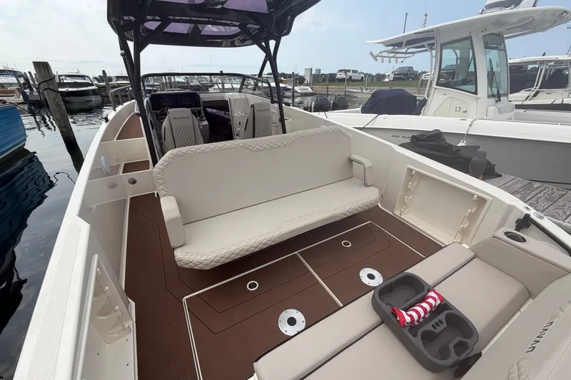 Slide: The Image of 2025 Navan S30 boat interior with seating and cup holders at a marina. - 9