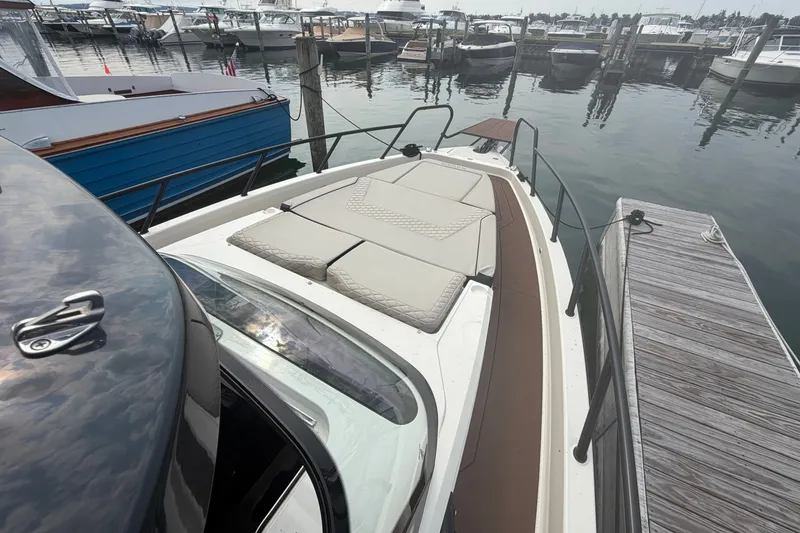 Slide: The Image of 2025 Navan S30 boat docked at marina with cushioned deck seating. - 14