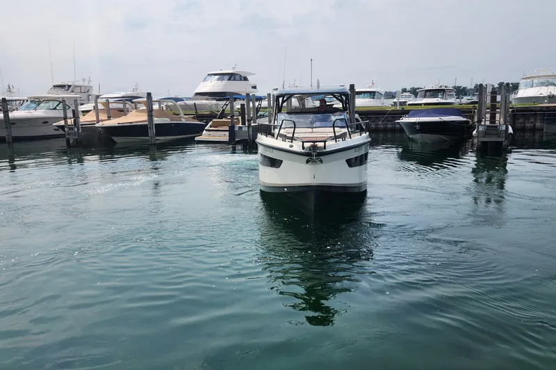Slide: The Image of 2025 Navan S30 boat navigating marina, surrounded by docked yachts. - 3