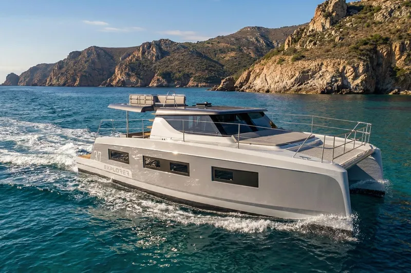 Slide: The Image of 2025 Aventura 37 Trawler cruising near rocky coastline in clear blue waters. - 20