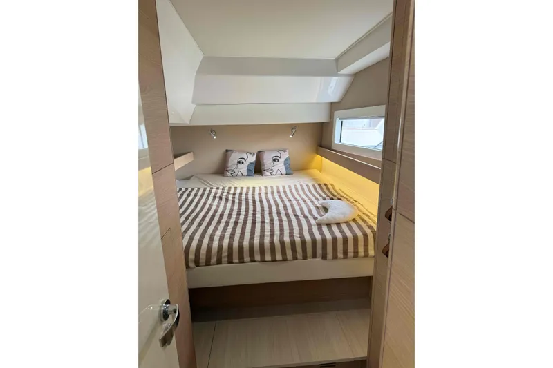 Slide: The Image of Cozy bedroom in 2026 Aventura 37 Explorer Trawler with striped bedding and decorative pillows. - 30