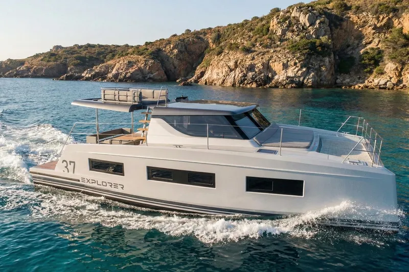 Slide: The Image of 2025 Aventura 37 Trawler cruising near rocky coastline. - 17
