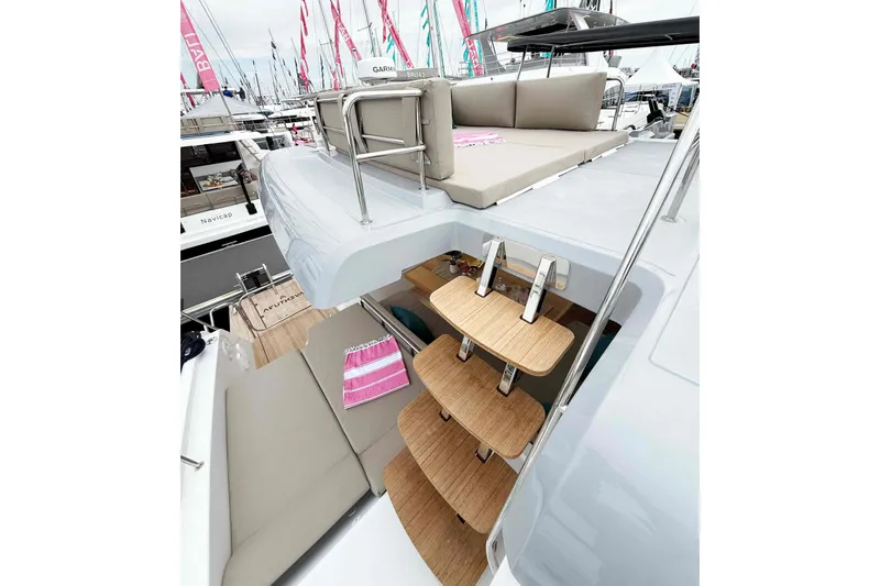 Slide: The Image of Aventura 37 Explorer Trawler 2026 with upper deck seating and wooden steps at a boat show. - 35
