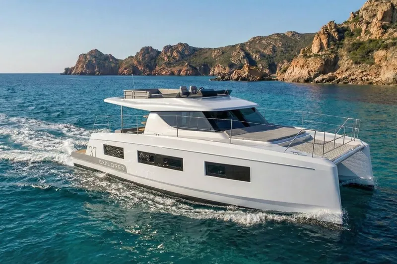 Slide: The Image of Aventura 37 Trawler 2025 cruising near rocky coastline in clear blue waters. - 21