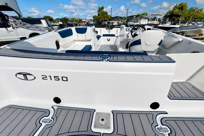 Slide: The Image of 2022 Tahoe 2150 boat interior with seating and steering wheel, under a clear blue sky. - 33