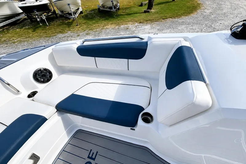 Slide: The Image of 2022 Tahoe 2150 boat interior with blue and white seating, cup holders, and speaker. - 28