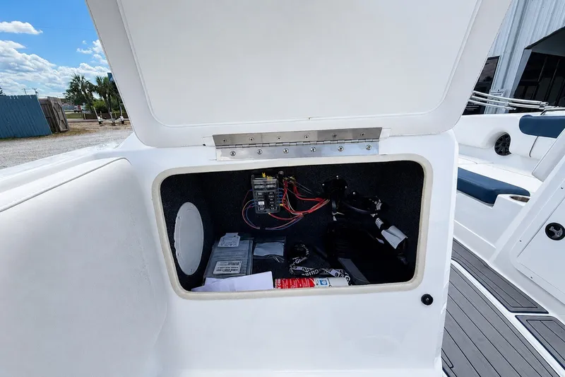Slide: The Image of Open storage compartment on a 2022 Tahoe 2150 boat, showing wiring and equipment. - 18