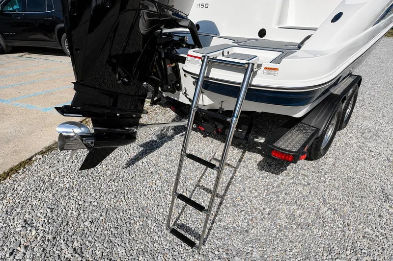 Slide: The Image of 2022 Tahoe 2150 boat with ladder and trailer on gravel surface. - 37