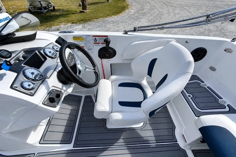 Slide: The Image of 2022 Tahoe 2150 boat cockpit with steering wheel, gauges, and white seating. - 31