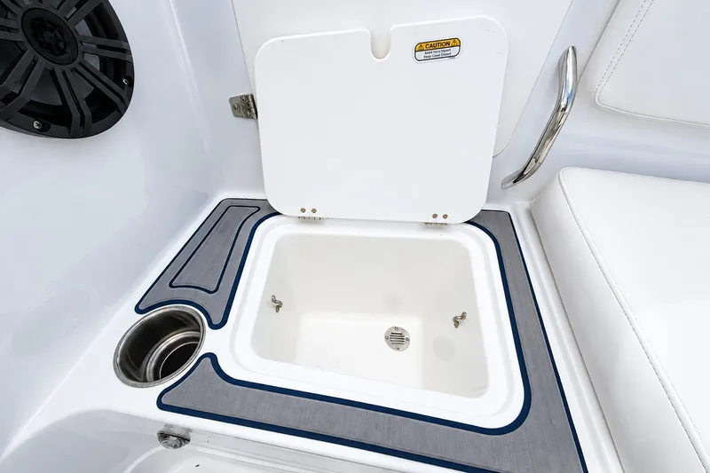 Slide: The Image of 2022 Tahoe 2150 boat interior with open storage compartment and cup holder. - 15