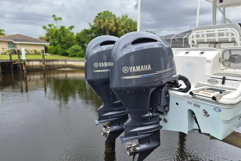 Slide: The Image of Twin Yamaha outboard engines on a 2023 Sea Fox 268 Commander boat, docked by a waterfront. - 6