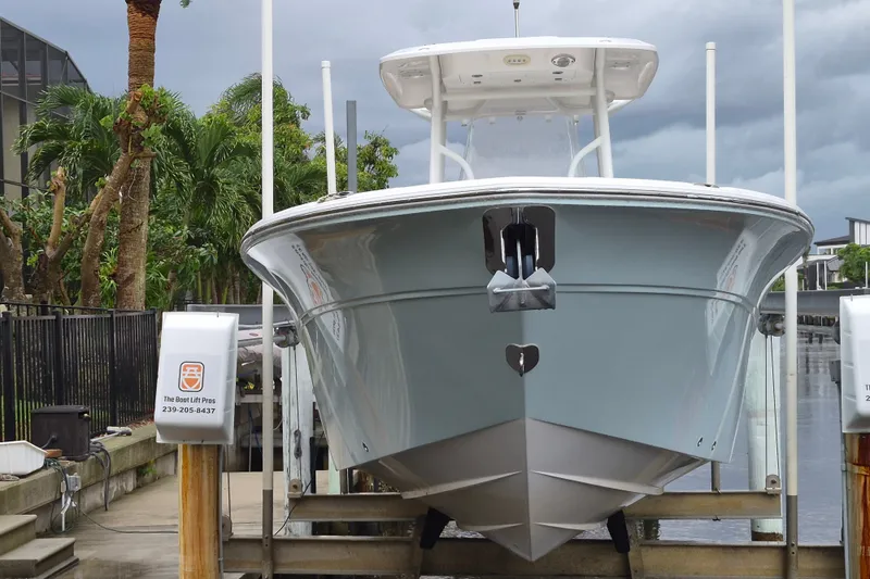 Slide: The Image of 2023 Sea Fox 268 Commander boat on lift, dockside with palm trees. - 5