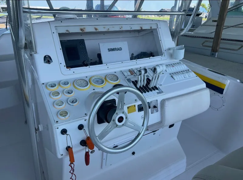 Slide: The Image of The image shows the helm of a 2001 Donzi 352F with various gauges and a Simrad display. - 12