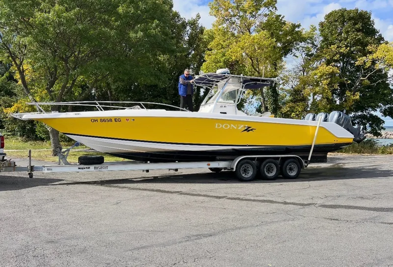 Slide: The Image of 2001 Donzi 352F on a trailer, yellow and white, with three outboard engines. - 3