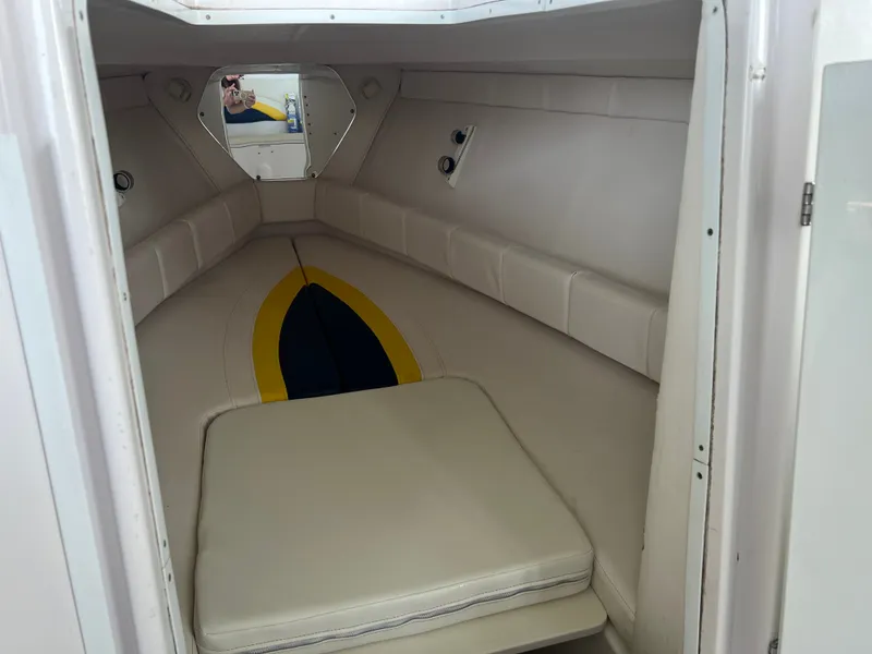 Slide: The Image of The cabin of the 2001 Donzi 352F features a cushioned berth with white and blue accents. - 17